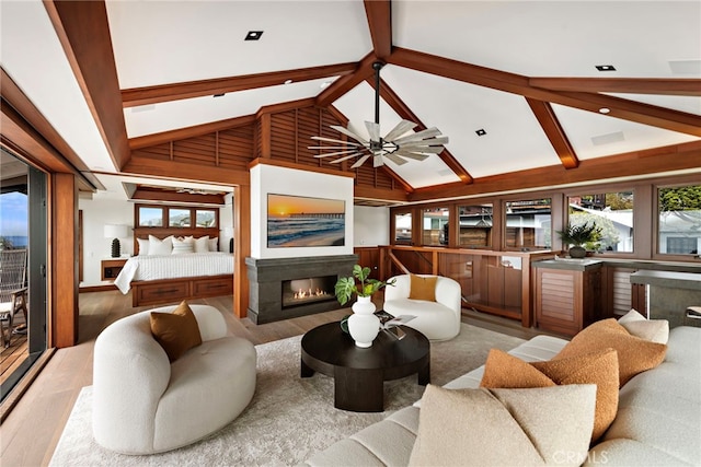 living room featuring a glass covered fireplace, wood finished floors, high vaulted ceiling, and beamed ceiling