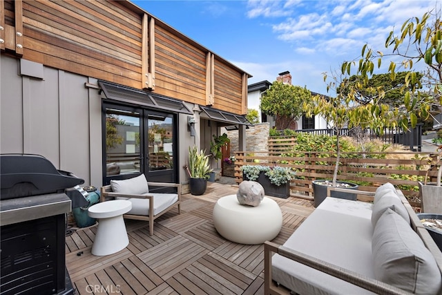 view of patio / terrace with an outdoor living space, fence, and a deck