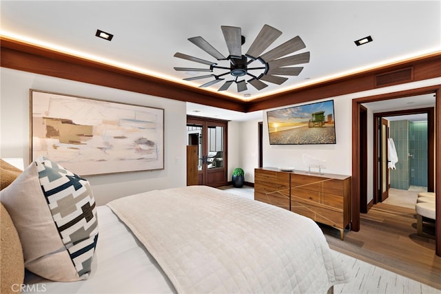 bedroom with light wood-style floors, a ceiling fan, and visible vents