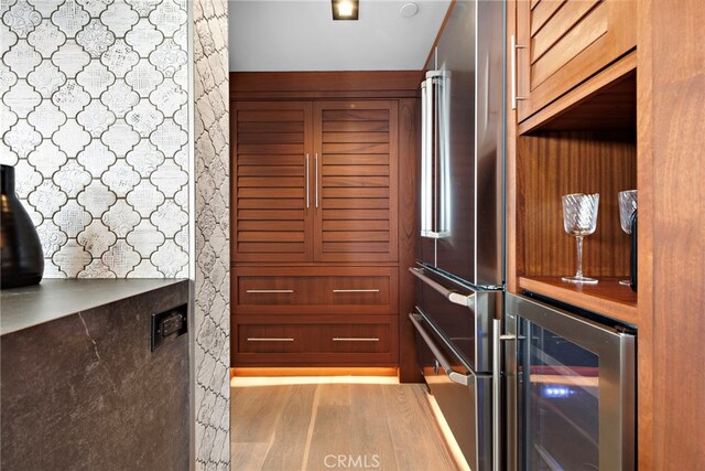 details with beverage cooler, high end fridge, and wood finished floors