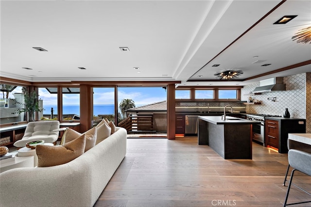 living area featuring crown molding, a water view, and wood finished floors