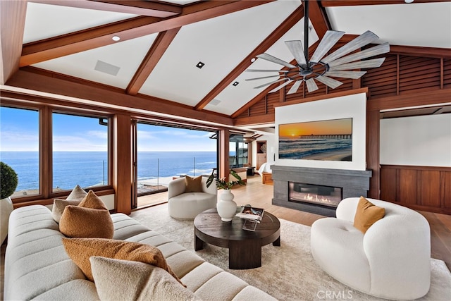living room with wooden walls, beam ceiling, a ceiling fan, and wood finished floors