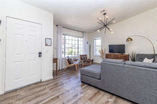 1929 Casa Linda St, Needles, CA 92363 - living room with visible vents, light wood-type flooring, a notable chandelier, and lofted ceiling