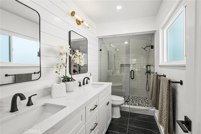 full bathroom with marble finish floor, a sink, a shower stall, and double vanity