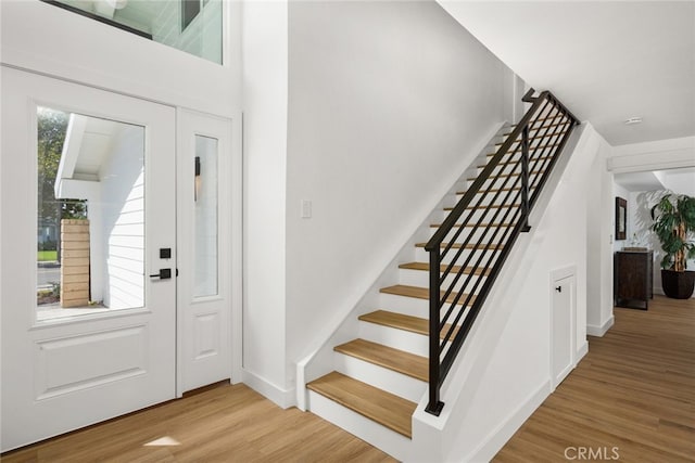 entryway with stairway, baseboards, and wood finished floors