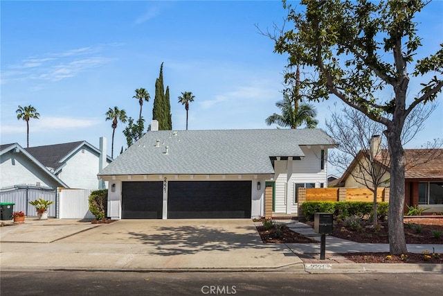 view of front of house with fence, driveway, a chimney, and a garage