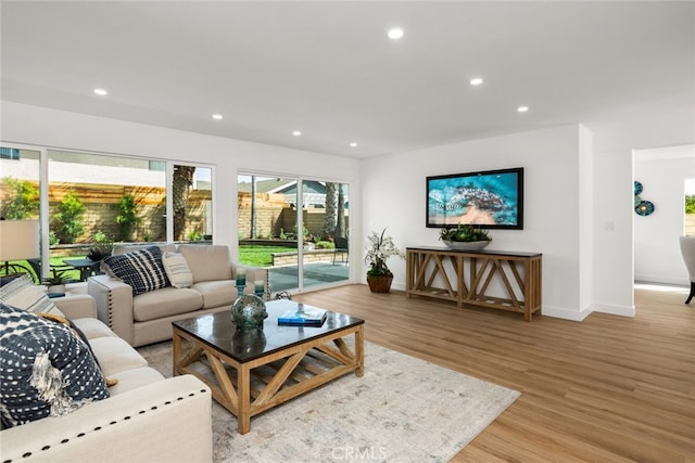 living room with baseboards, light wood-type flooring, and recessed lighting