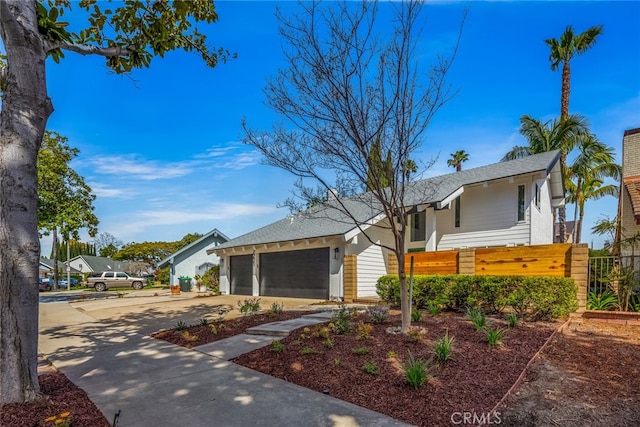single story home featuring a garage, fence private yard, driveway, and a shingled roof