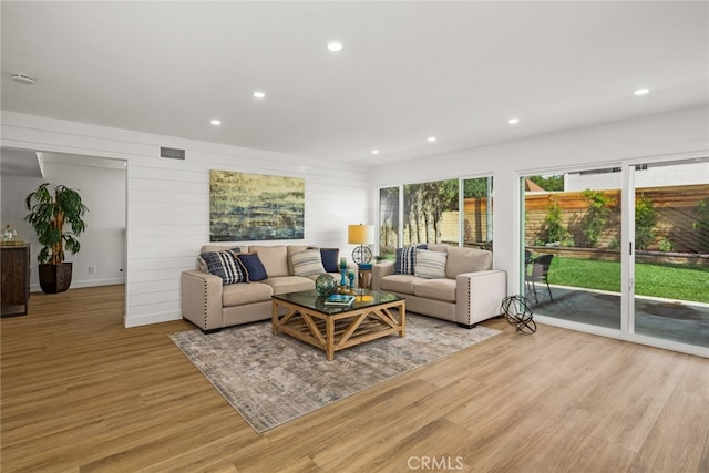 living room featuring recessed lighting, visible vents, and light wood-type flooring