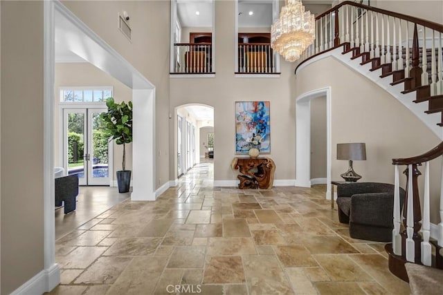 1489 Caballero Rd, Arcadia, CA 91006 - foyer featuring arched walkways, stone tile flooring, a towering ceiling, stairway, and french doors