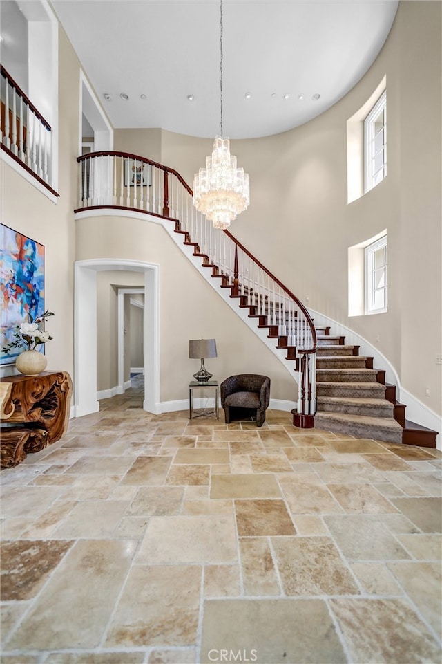 1489 Caballero Rd, Arcadia, CA 91006 - foyer with a towering ceiling, stairs, stone tile floors, a chandelier, and arched walkways