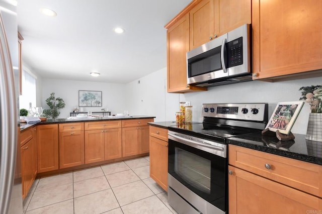 992 Churrituck Dr, San Diego, CA 92154 - kitchen with brown cabinetry, appliances with stainless steel finishes, light tile patterned floors, dark stone countertops, and recessed lighting