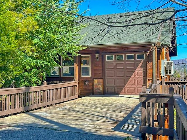 view of front facade with concrete driveway, a garage, and a shingled roof