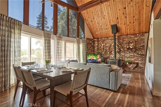 sunroom / solarium featuring beamed ceiling and a wood stove