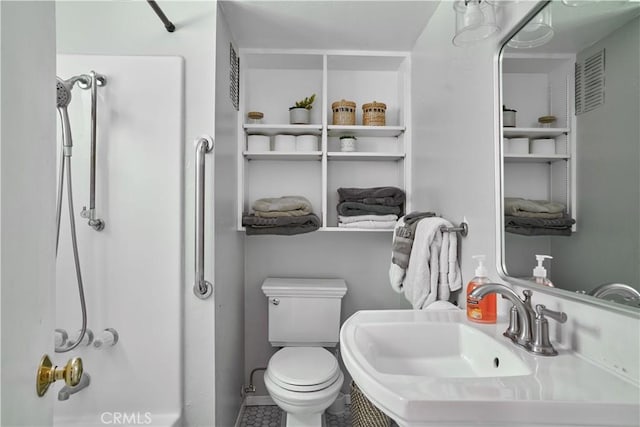 bathroom featuring toilet, visible vents, tile patterned flooring, and a shower