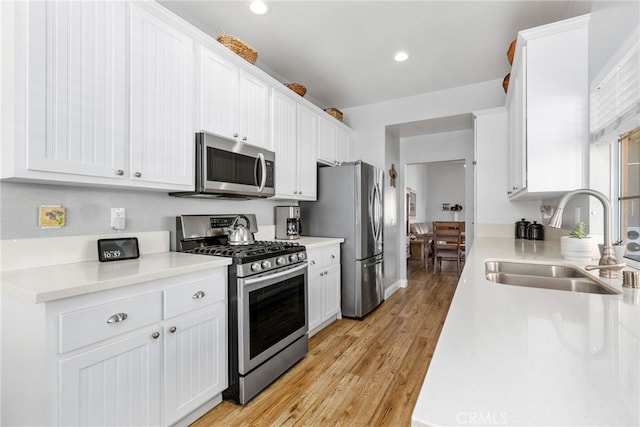 27263 Family Cir, Menifee, CA 92586 - kitchen with light countertops, white cabinets, stainless steel appliances, light wood finished floors, and a sink
