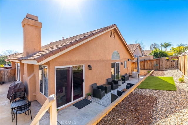 27263 Family Cir, Menifee, CA 92586 - rear view of house featuring a tiled roof, a fenced backyard, stucco siding, a patio area, and a chimney
