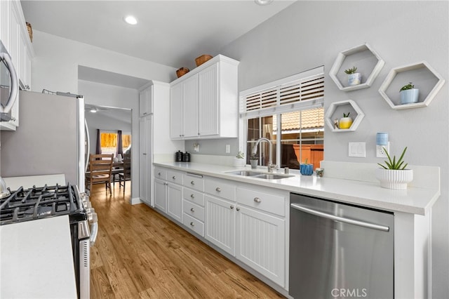27263 Family Cir, Menifee, CA 92586 - kitchen featuring white cabinets, a sink, light wood-type flooring, a ceiling fan, and stainless steel appliances