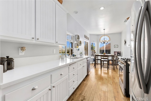 27263 Family Cir, Menifee, CA 92586 - kitchen with a notable chandelier, light countertops, white cabinetry, appliances with stainless steel finishes, and a sink