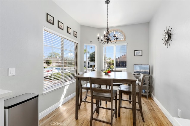 27263 Family Cir, Menifee, CA 92586 - dining room with light wood-type flooring, an inviting chandelier, and baseboards