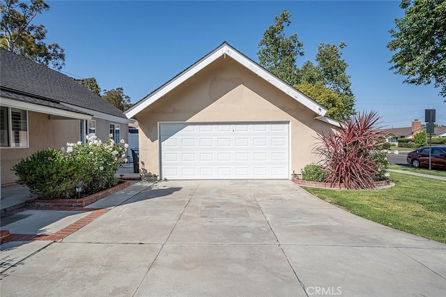 view of front facade with concrete driveway, a garage, and stucco siding