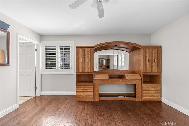 unfurnished living room featuring baseboards, ceiling fan, and wood finished floors