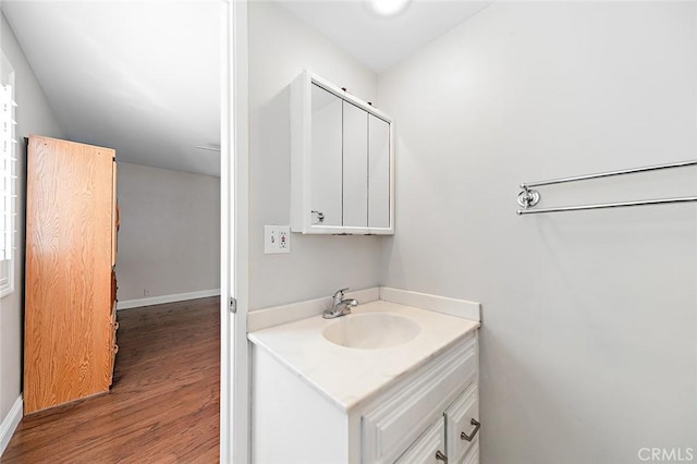 bathroom featuring vanity, baseboards, and wood finished floors