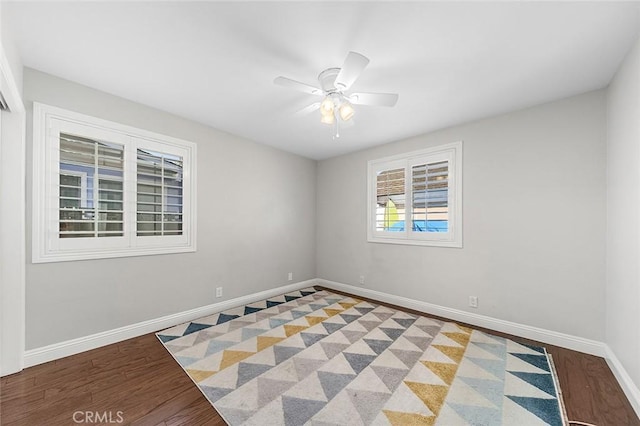 unfurnished room featuring baseboards, ceiling fan, and wood finished floors