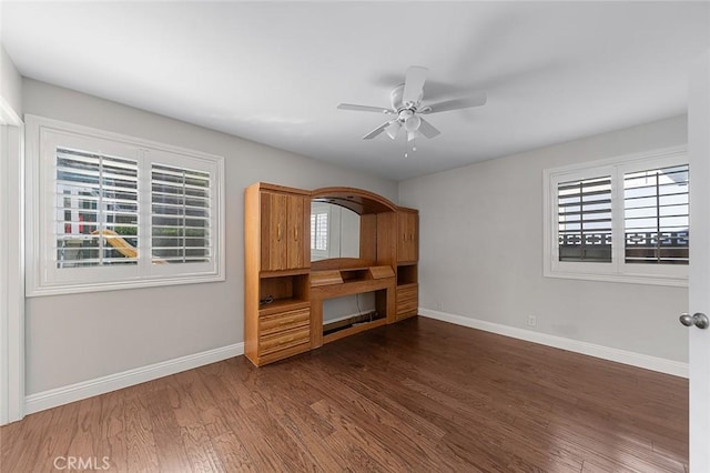 unfurnished living room featuring baseboards, a healthy amount of sunlight, and wood finished floors