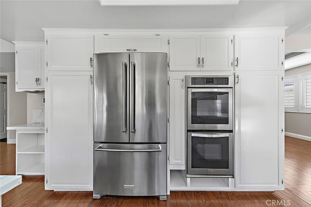 kitchen featuring appliances with stainless steel finishes, white cabinets, baseboards, and dark wood-style flooring