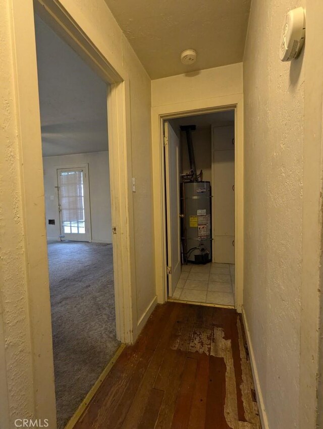 548 S Plumas St, Willows, CA 95988 - corridor featuring water heater, a textured wall, baseboards, and hardwood / wood-style flooring