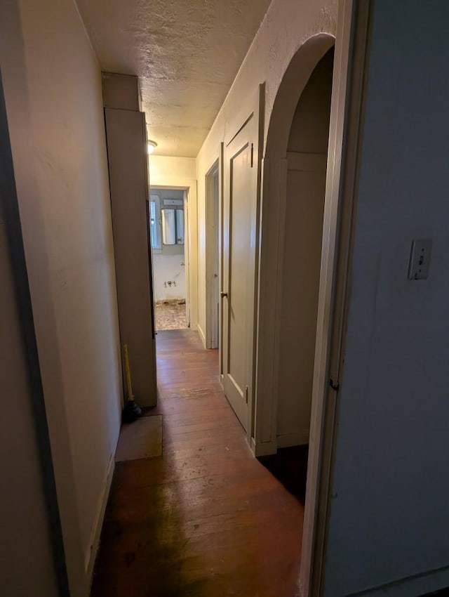 548 S Plumas St, Willows, CA 95988 - hallway featuring a textured ceiling, wood finished floors, baseboards, and arched walkways
