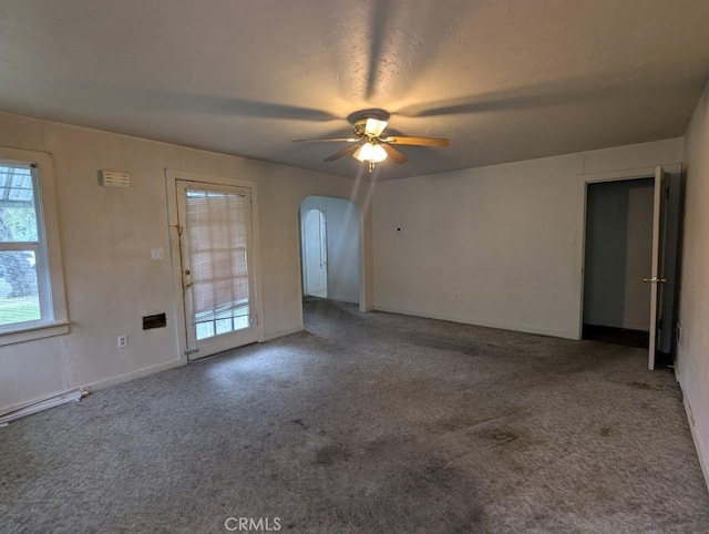 548 S Plumas St, Willows, CA 95988 - carpeted empty room featuring arched walkways, a healthy amount of sunlight, and a ceiling fan
