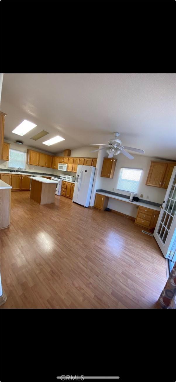 6117 Juniper Rd, Lake Isabella, CA 93240 - kitchen featuring white appliances, light wood-style flooring, light countertops, ceiling fan, and a center island