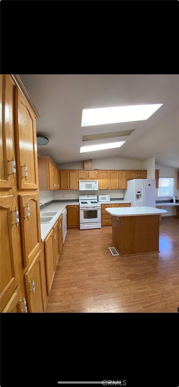 6117 Juniper Rd, Lake Isabella, CA 93240 - kitchen featuring white appliances, light countertops, a center island, a sink, and light wood-style floors