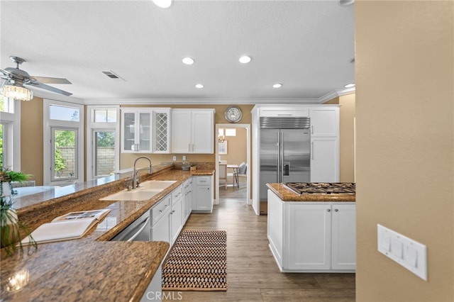 kitchen featuring appliances with stainless steel finishes, crown molding, visible vents, ceiling fan, and a sink