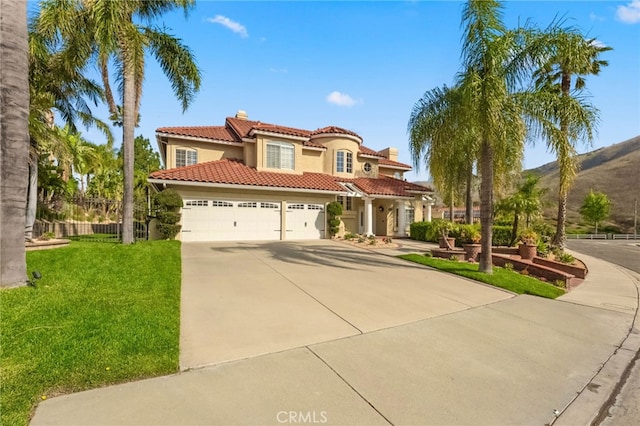 mediterranean / spanish-style home featuring a garage, stucco siding, a tile roof, a chimney, and driveway