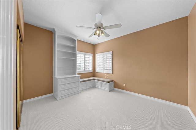 empty room with baseboards, a ceiling fan, and light colored carpet