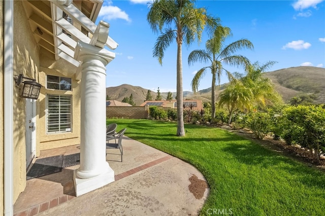 view of yard with a mountain view, fence, and a patio area