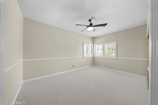 spare room featuring a textured ceiling, baseboards, a ceiling fan, and carpet floors