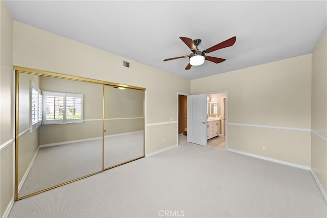 unfurnished bedroom with a closet, a ceiling fan, visible vents, carpet flooring, and baseboards