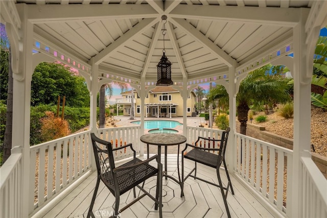 wooden terrace with an outdoor pool and a gazebo