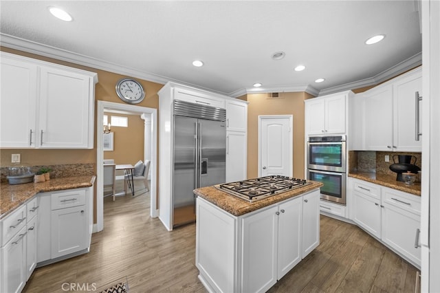 24240 Avenida De Marcia, Yorba Linda, CA 92887 - kitchen featuring appliances with stainless steel finishes, ornamental molding, white cabinets, light wood-type flooring, and a center island