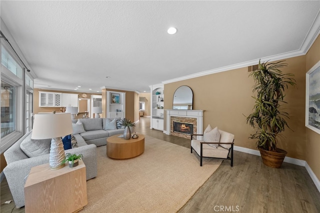 24240 Avenida De Marcia, Yorba Linda, CA 92887 - living area featuring a warm lit fireplace, wood finished floors, ornamental molding, recessed lighting, and built in shelves