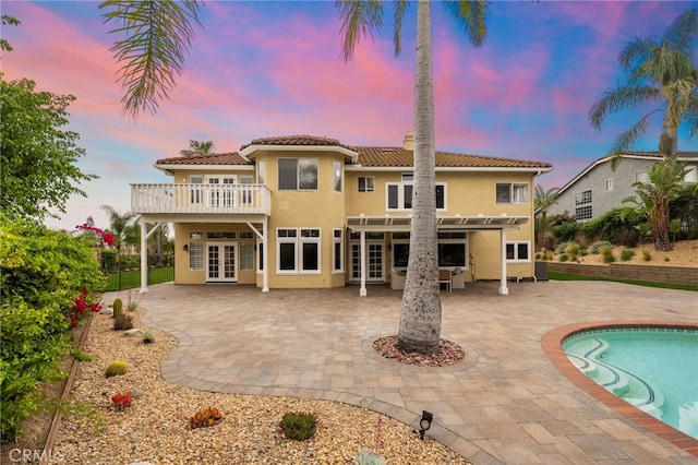 24240 Avenida De Marcia, Yorba Linda, CA 92887 - back of property at dusk with french doors, a pergola, an outdoor pool, and stucco siding