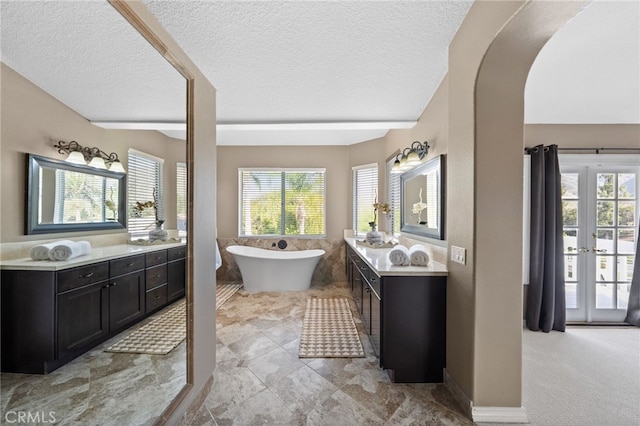 24240 Avenida De Marcia, Yorba Linda, CA 92887 - full bath with two vanities, healthy amount of natural light, a textured ceiling, a freestanding bath, and lofted ceiling