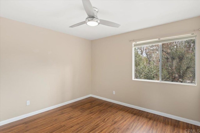 empty room with wood finished floors, baseboards, and ceiling fan