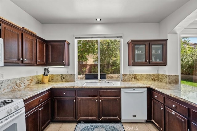 kitchen featuring plenty of natural light, white appliances, a sink, and light tile patterned floors