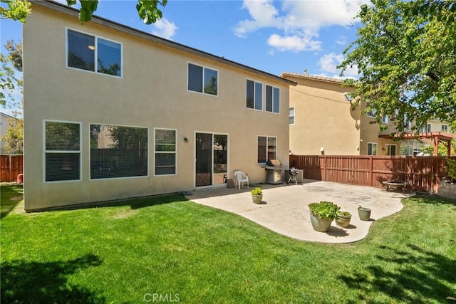 back of property featuring a patio, a yard, stucco siding, and fence
