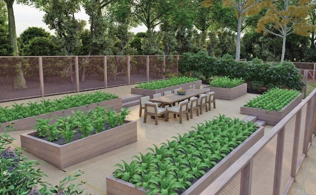 surrounding community featuring a vegetable garden, fence, outdoor dining space, and a patio